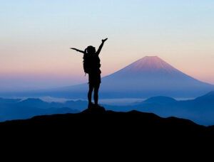 Person raising arms at mountain summit