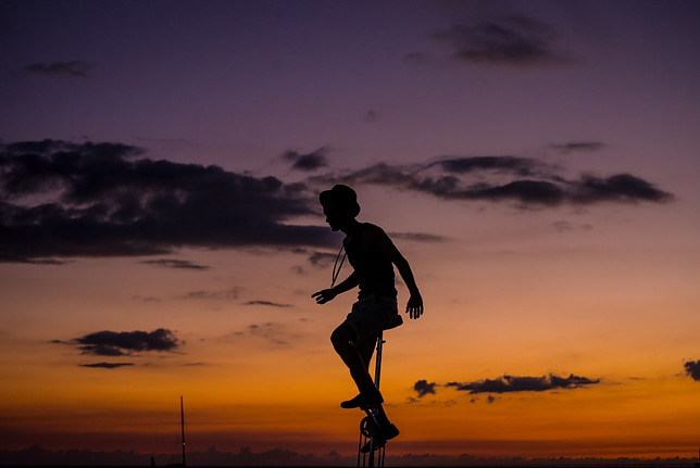 Image shows a black silhouette of a female on a unicycle in the foreground and a twilight sky in the background