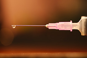 Injection needle with a droplet hanging from the tip