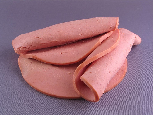 Image shows three slices of baloney on a purple background