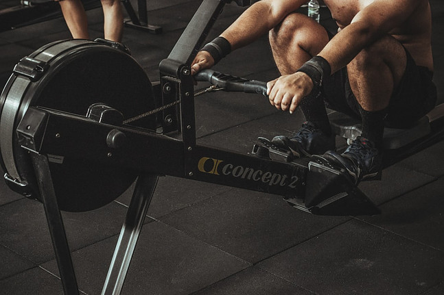 Image shows half of a concept2 indoor rower with an athlete in the ready position