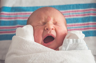 Image shows the face of a baby yawning